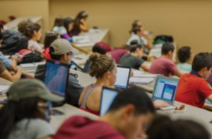 A classroom of students typing on laptops.